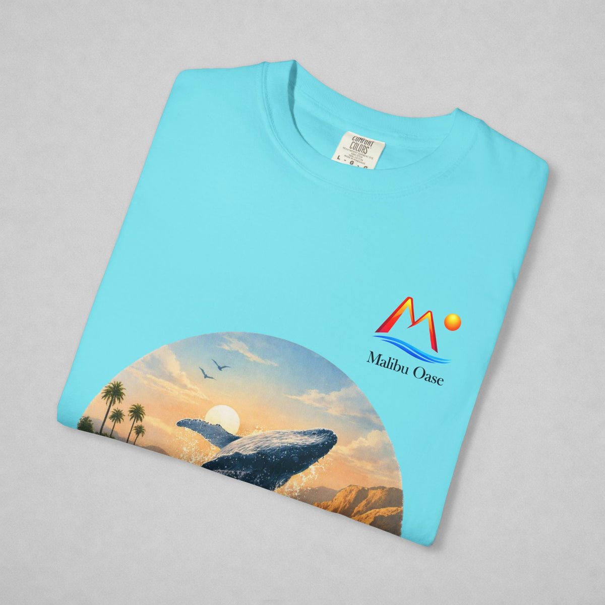 Folded Lagoon Blue T-shirt with breaching whale and logo.