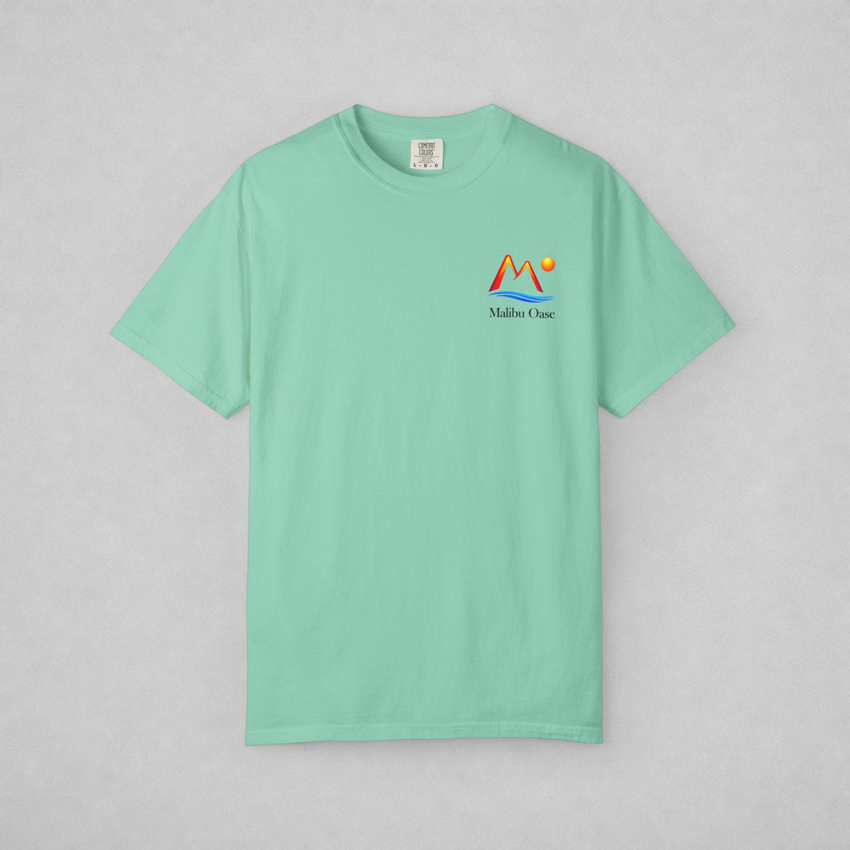 A mint green short-sleeve t-shirt with a small colorful 'M' mountain logo and the text 'Maldon Organic' printed on the left chest, displayed flat against a light gray background.