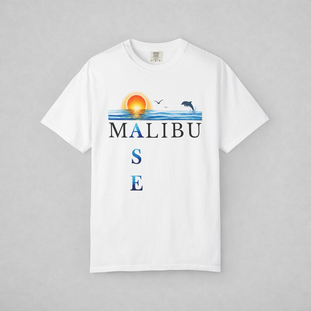 A white short-sleeve crewneck t-shirt featuring a graphic print of a sunset over blue water with a dolphin, birds, and the text 'MALIBU OASE', displayed on a neutral gray background.