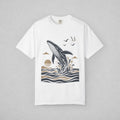 White. Short-sleeve crewneck t-shirt with a graphic print of a whale jumping out of the water, birds, and a sun, displayed on a neutral gray background.