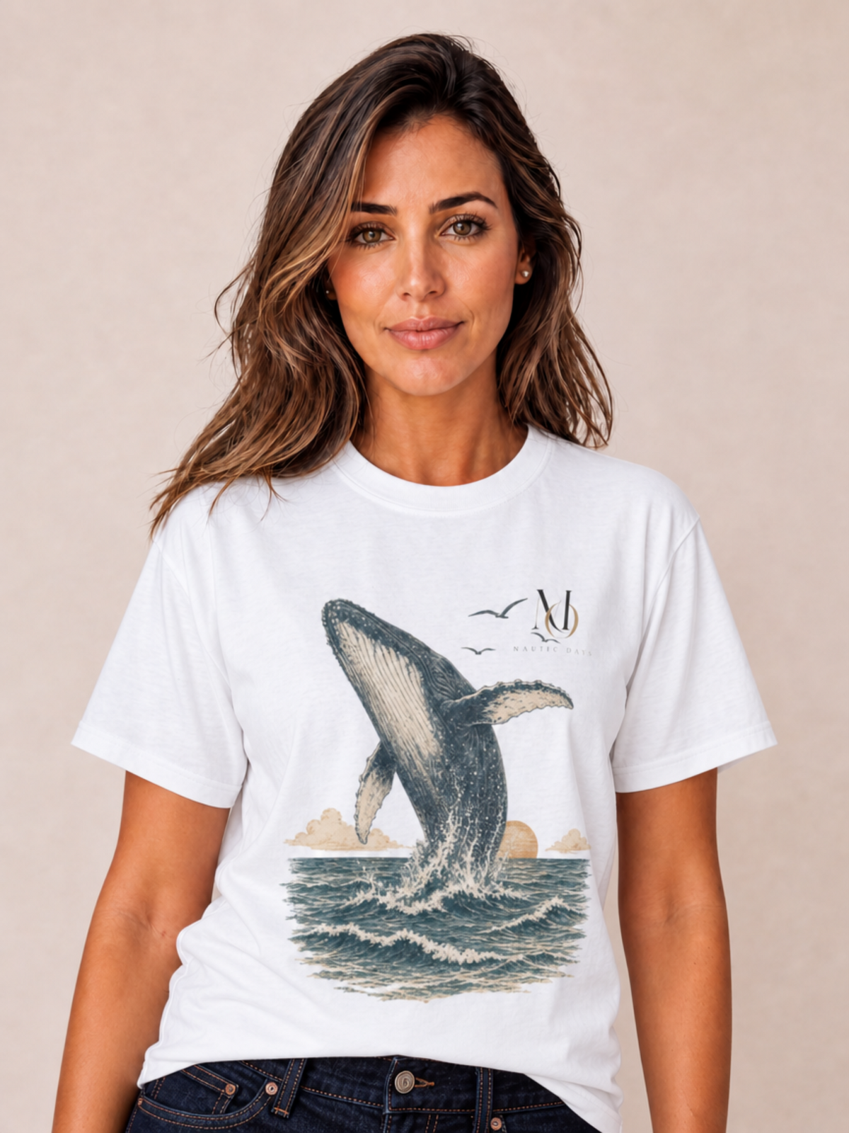 A woman wearing a white crewneck t-shirt with a graphic print of a humpback whale jumping from the ocean, set against a plain beige background.