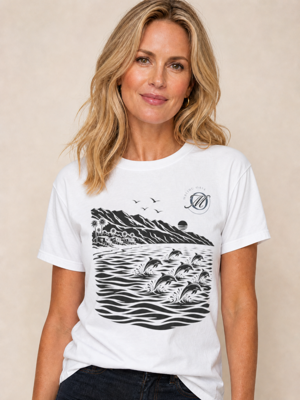 A woman wearing a white short-sleeve graphic t-shirt with a black print of dolphins in ocean waves and a circular logo on the left chest, set against a neutral beige background.