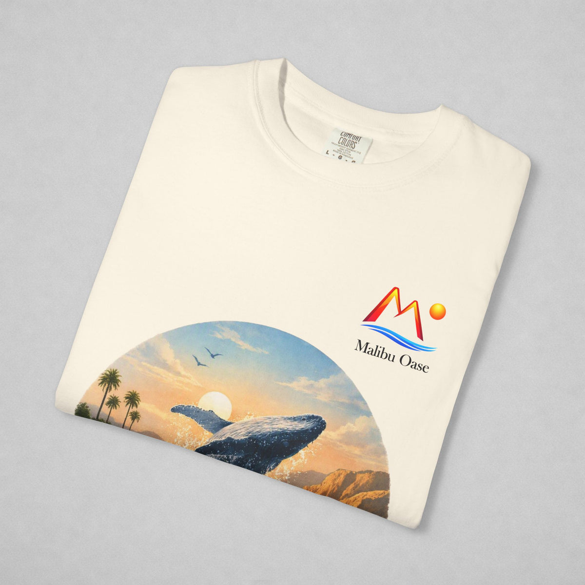 Folded Ivory T-shirt with breaching whale and logo.