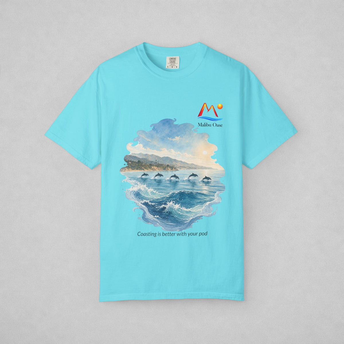 Lagoon Blue.  Short-sleeve t-shirt with a graphic print of dolphins in the ocean, with the text 'Coasting is better with your pod'.