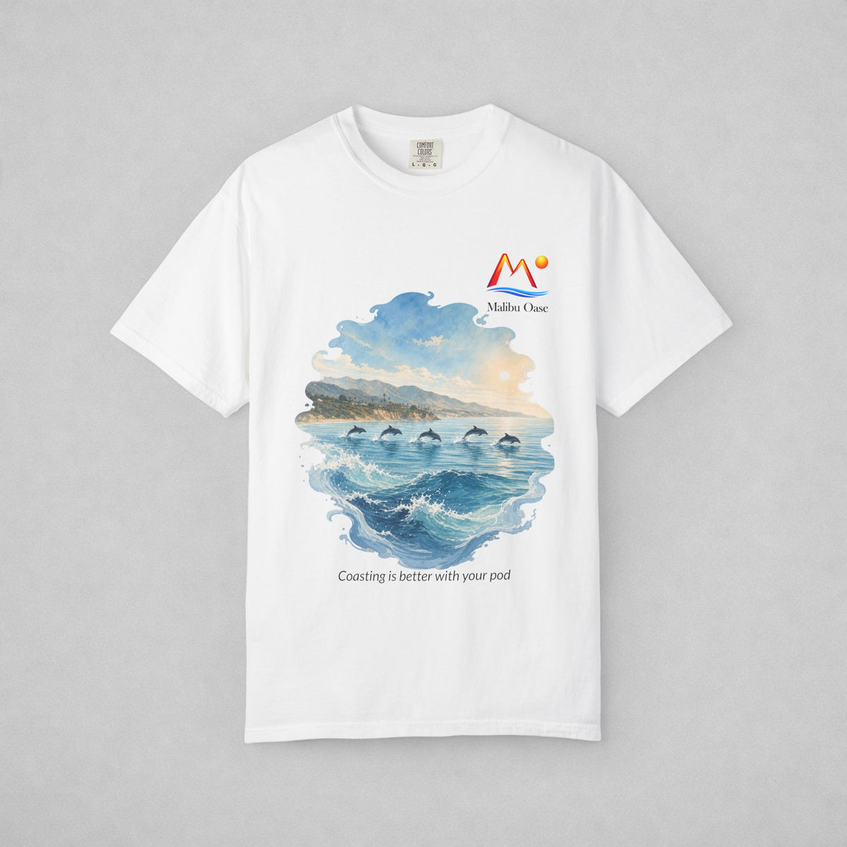 A white short-sleeve crewneck t-shirt with a watercolor-style graphic of dolphins in the blue ocean, with the text 'Coasting is better with your pod'.