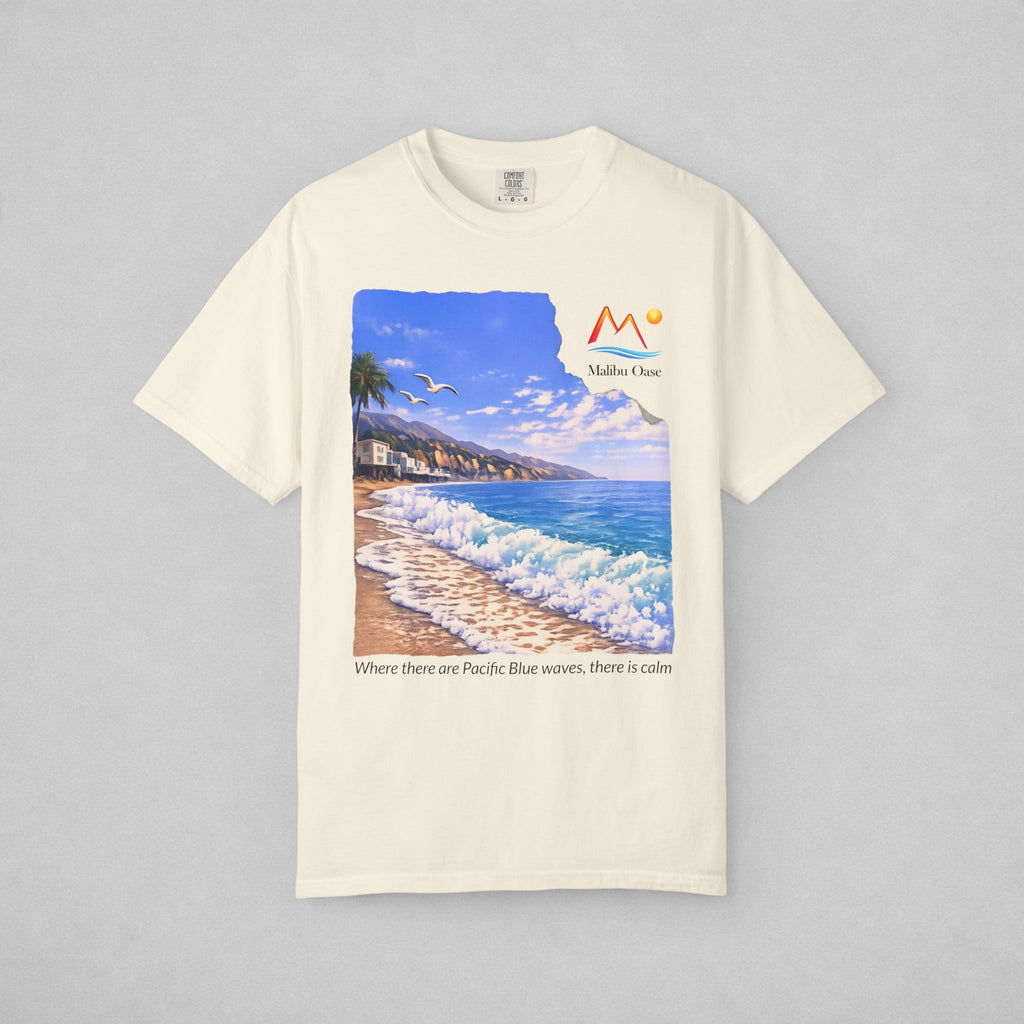 An off-white short-sleeve t-shirt with a large graphic print of a beach scene on the front with the logo 'Malibu Oase' and under the print there are the words 'Where there are Pacific Blue waves, there is calm'.